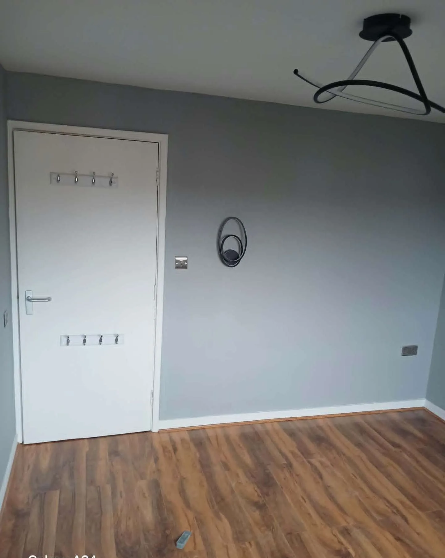 Bedroom repainted in cool grey with fresh white door and trims