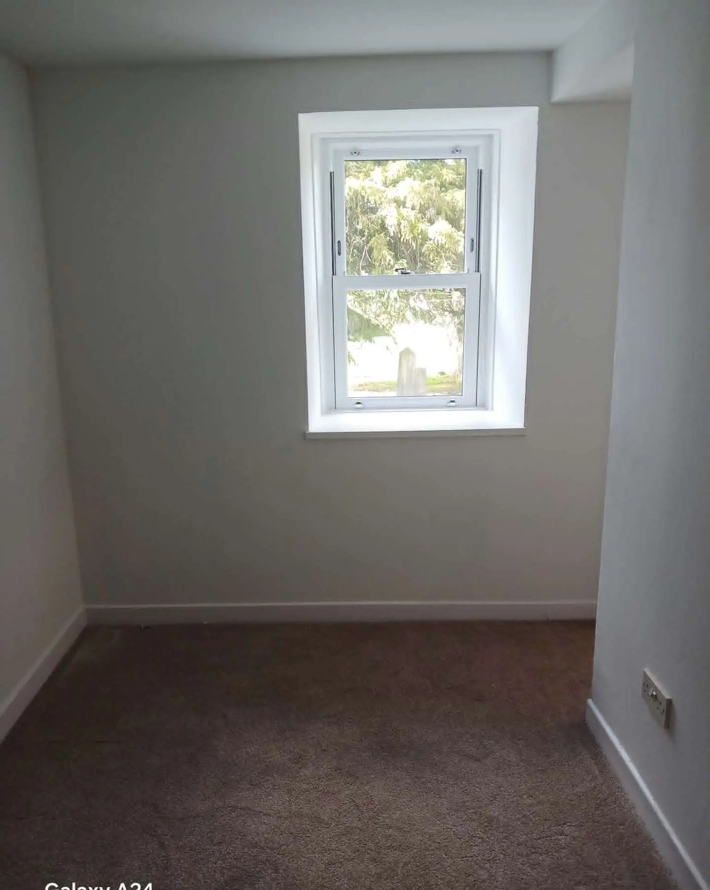Repainted bedroom in warm off-white with clean window reveals